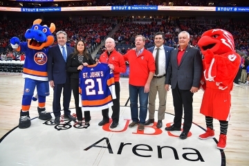 Group of leaders standing at center court of UBS Arena with mascots