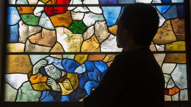 Student standing infront of stained glass window