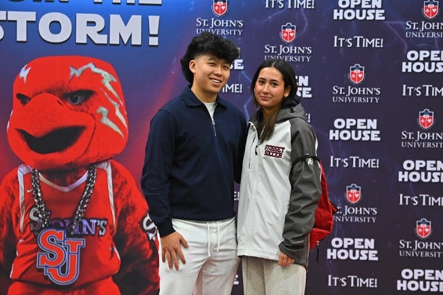 Two St. John's Open House participants posing infront of Johnny Thunderbird step and repeat